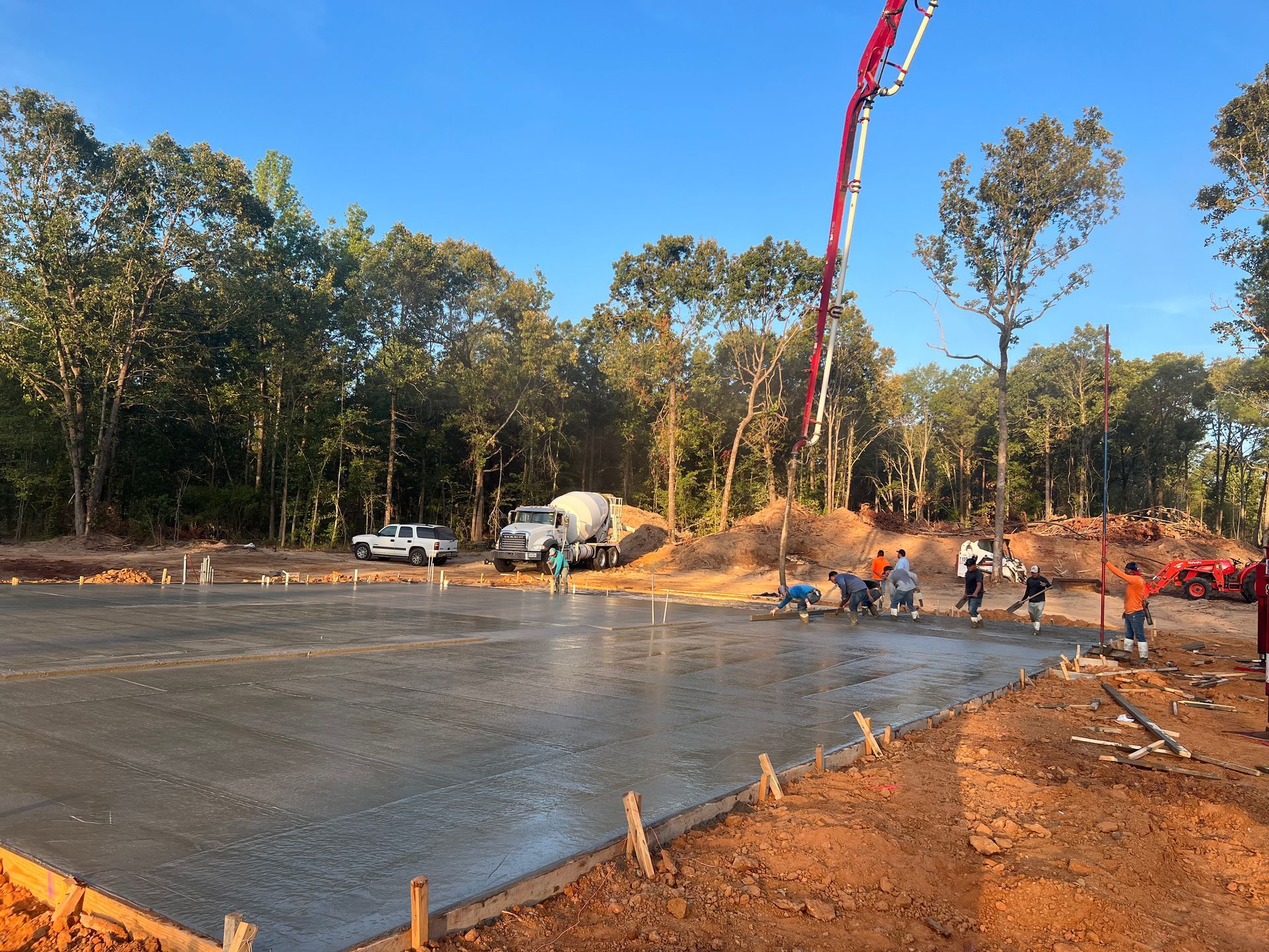 A large concrete slab is being poured on a construction site.