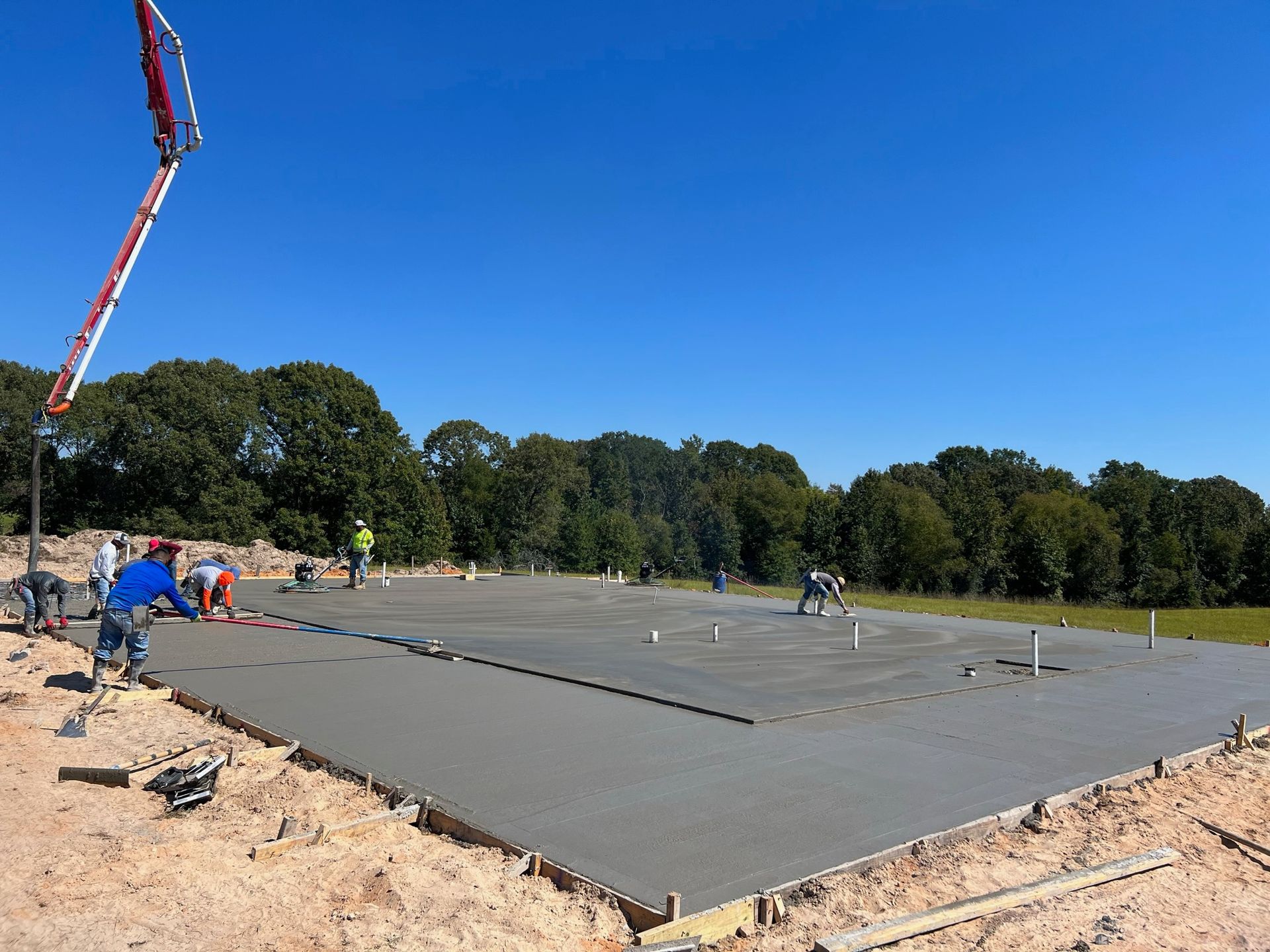 A group of construction workers are working on a concrete foundation.