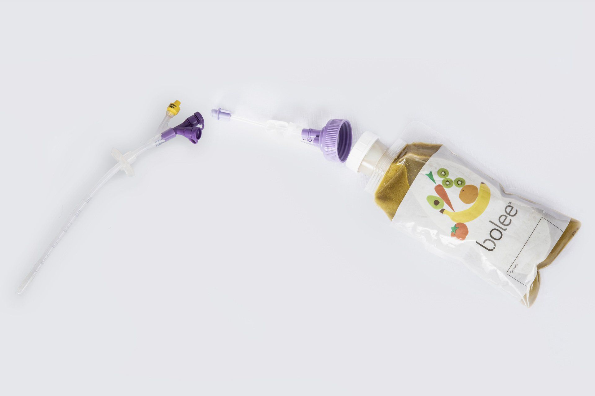 Filled Bolee Bag next to a Bolink Large Cap and bolus extension set