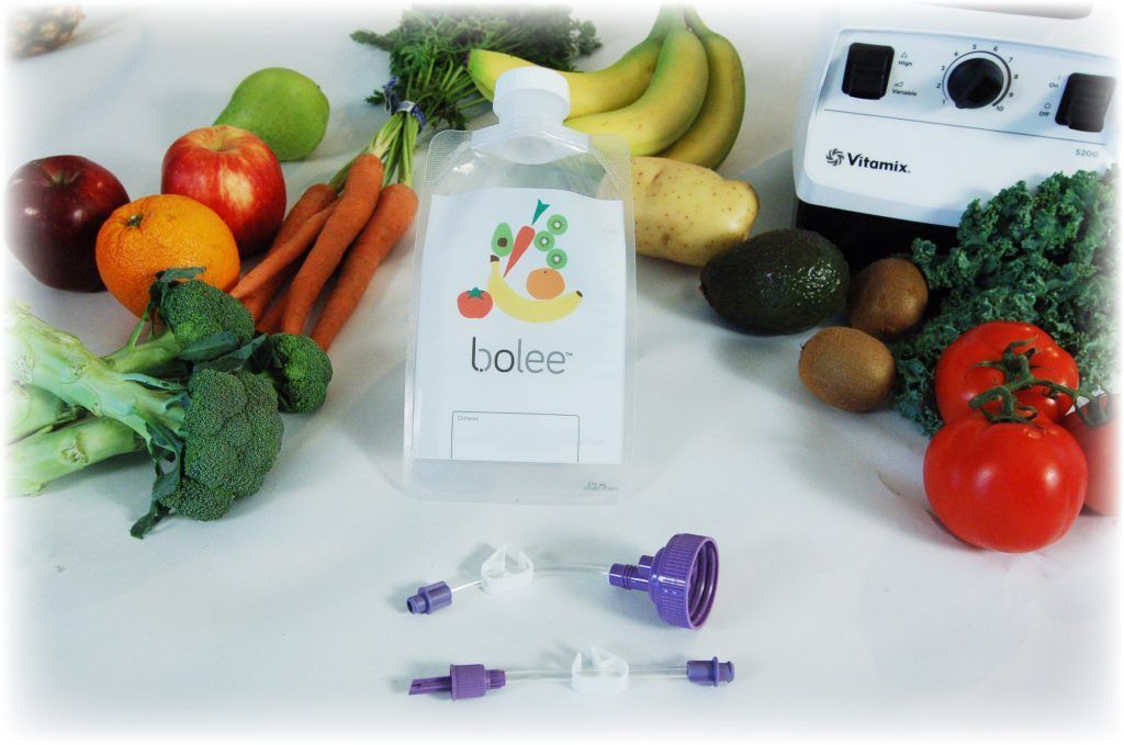 Bolee Bag, Bolink Large Cap and Bolink Small Cap in front of fruits, vegetables and a blender