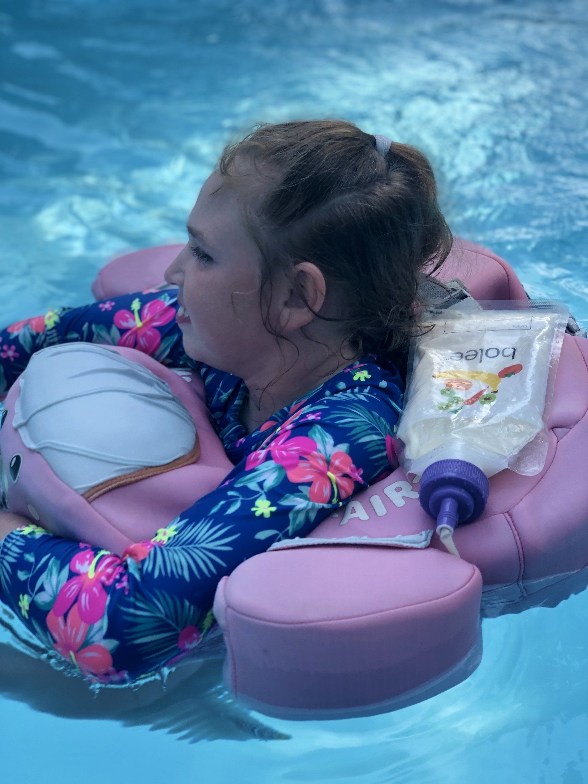 A girl in a swimming pool with a filled Bolee Bag.