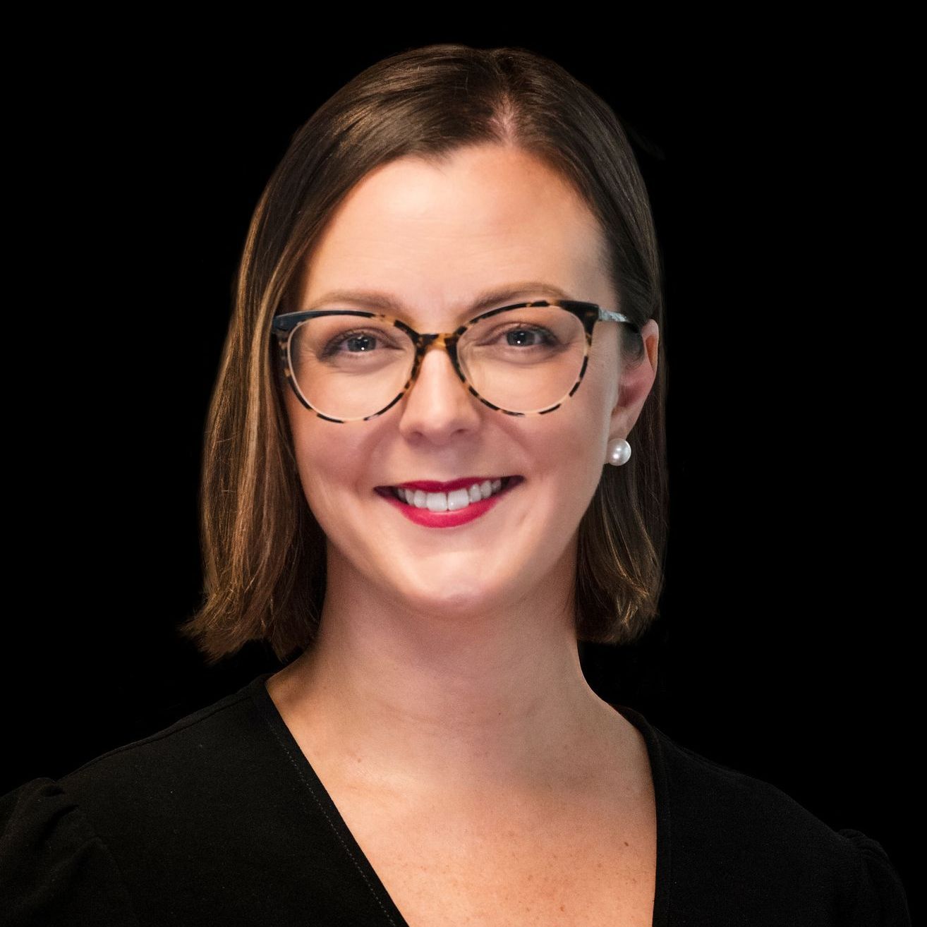 A woman wearing glasses and a black shirt smiles for the camera