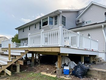 A house with a large deck and stairs in front of it.