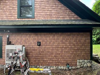A brick house with a ladder on the side of it.