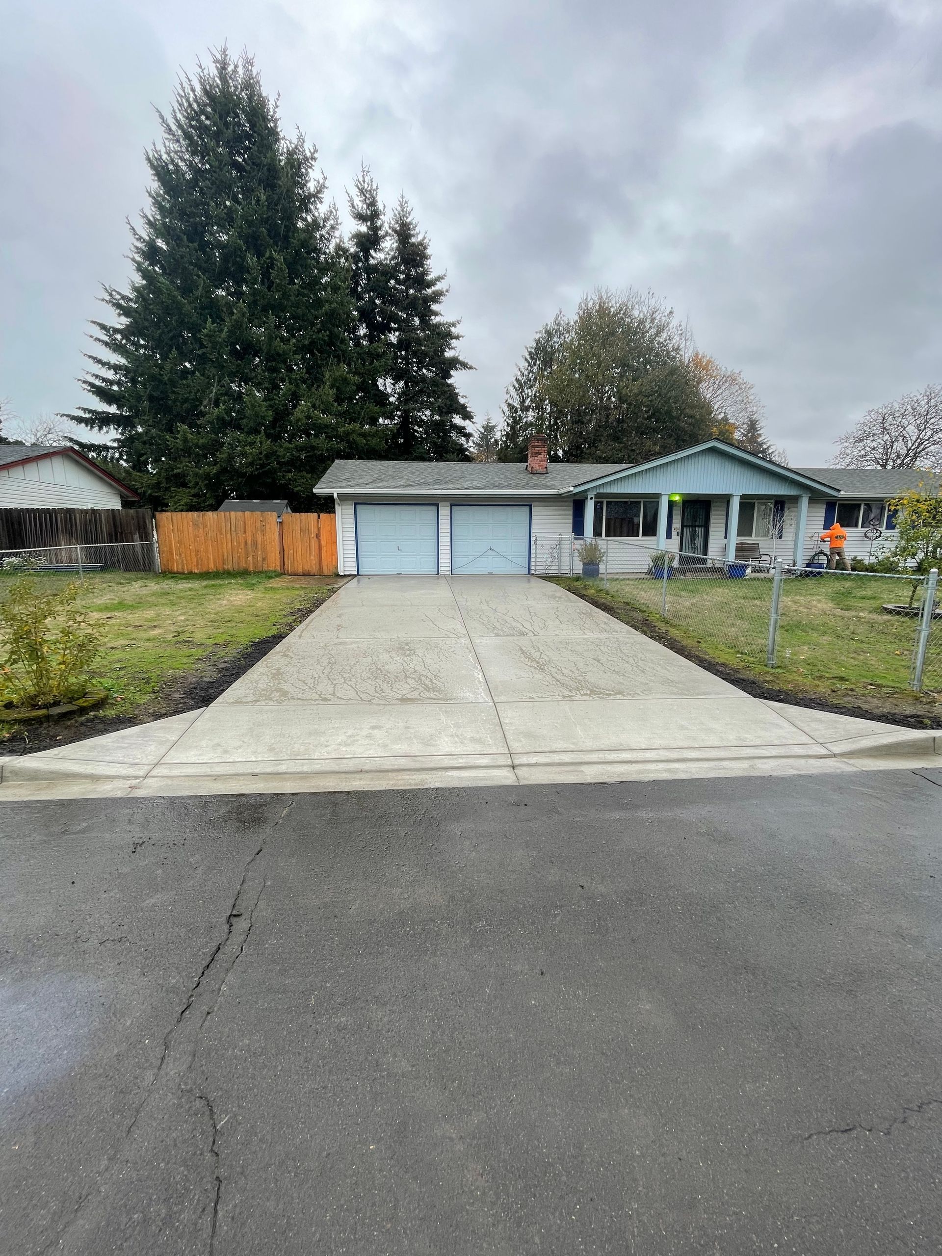 A red car is parked in front of a modern house.