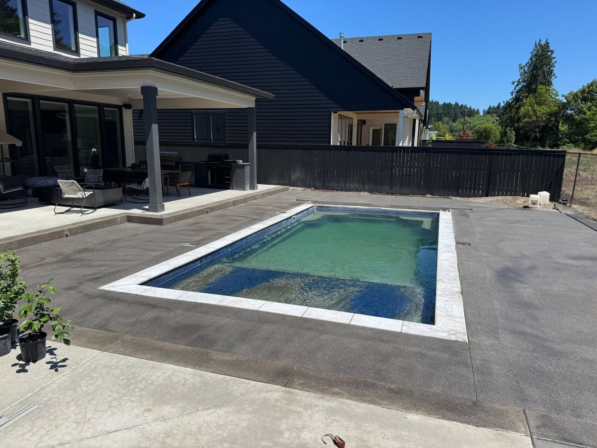 A brick driveway leading to a house with a lush green lawn.