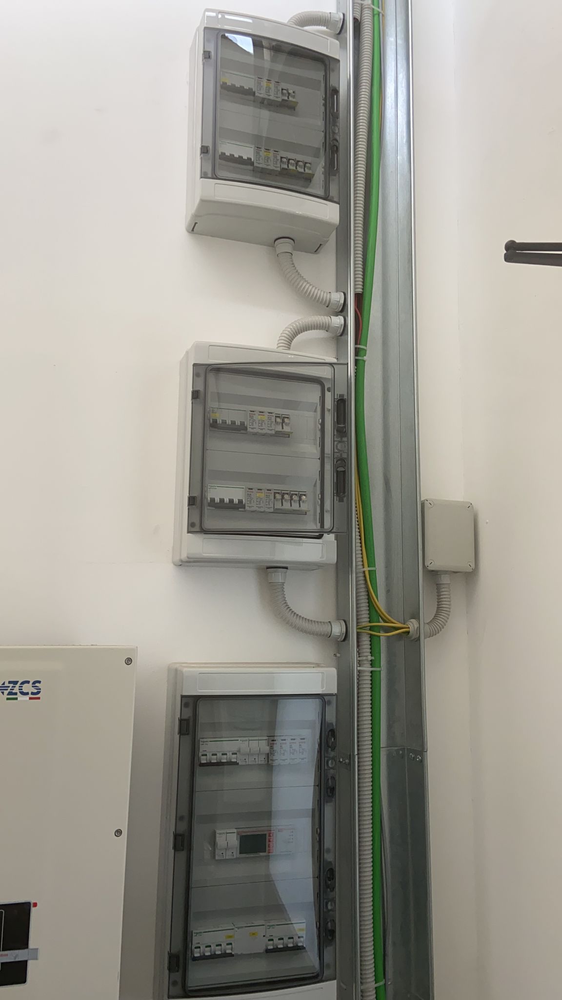 Un mucchio di scatole elettriche sono appese a una parete.