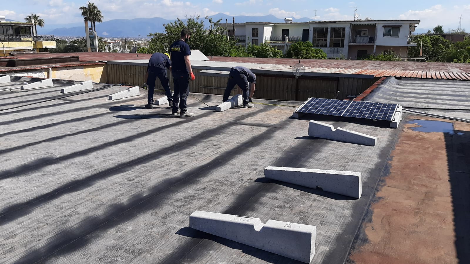Un gruppo di persone sta lavorando sul tetto di un edificio.