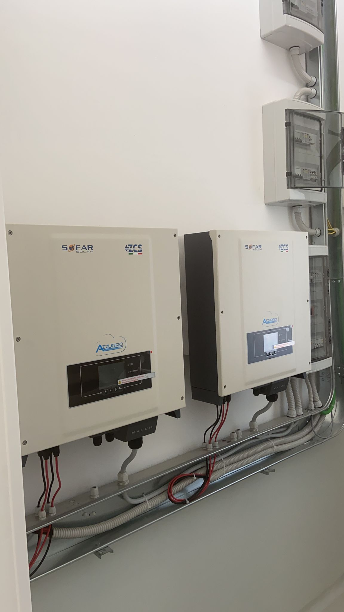 Due scatole bianche sono appese a una parete bianca.