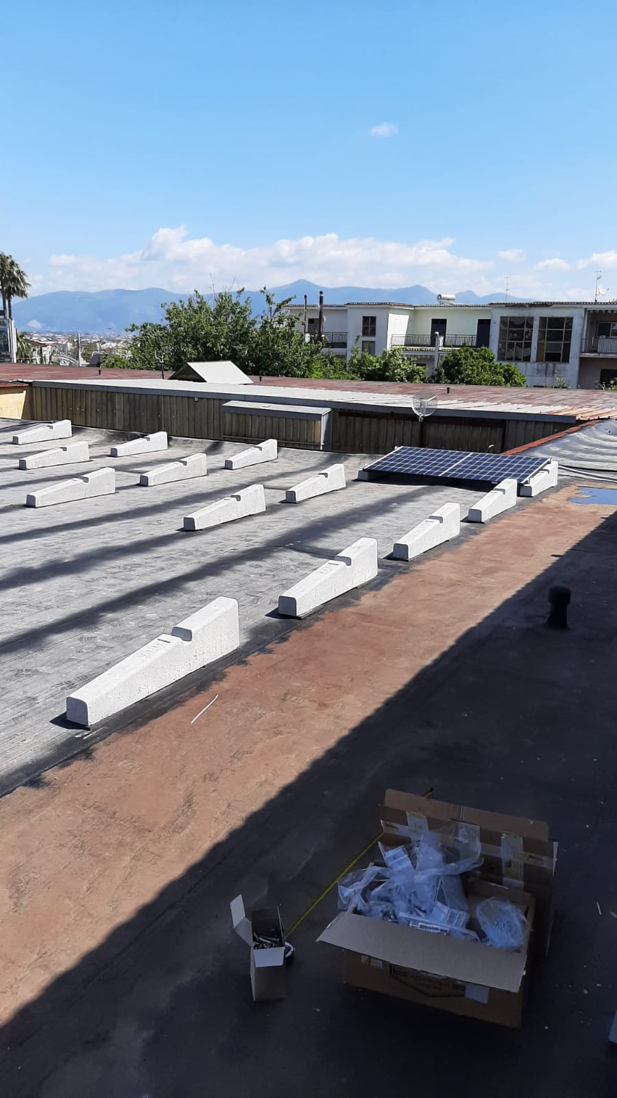 Un tetto con un sacco di blocchi di cemento e una scatola per terra.