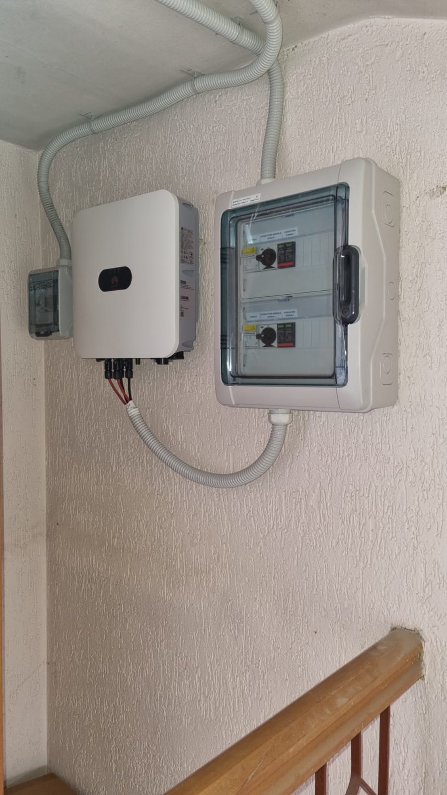 Una scatola bianca è appesa a una parete accanto a una scala.