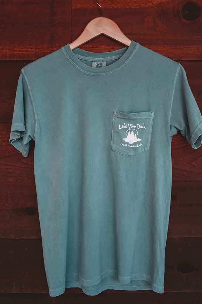 A green t-shirt is hanging on a wooden hanger.