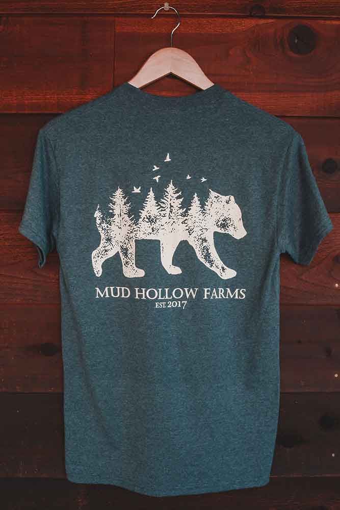 A t-shirt is hanging on a hanger on a wooden wall.