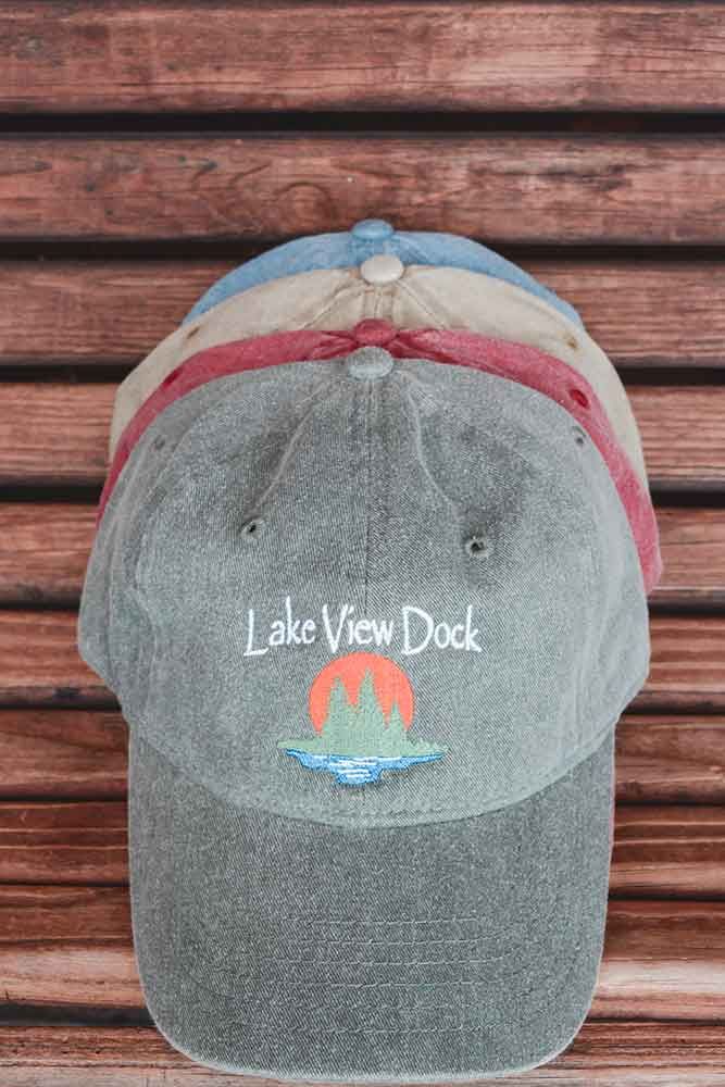 A baseball cap is stacked on top of each other on a wooden table.