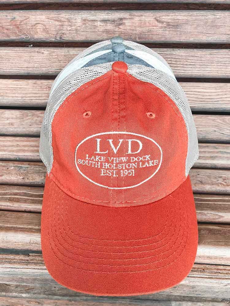 A red and gray baseball cap is sitting on a wooden table.