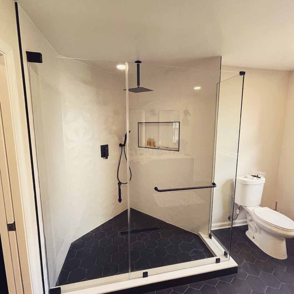 A bathroom with a toilet and a shower with a glass door.