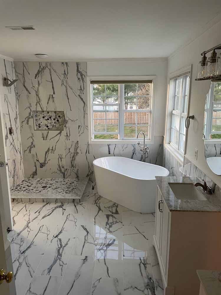 A bathroom with a tub , sink , and shower.