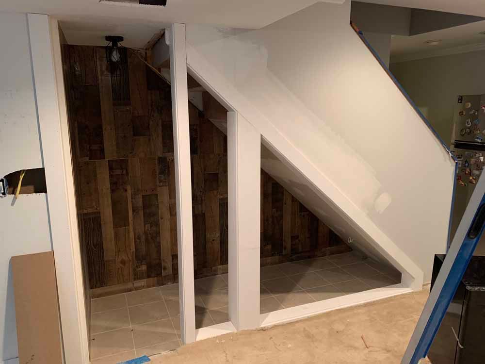 A room with a staircase and a wooden wall.