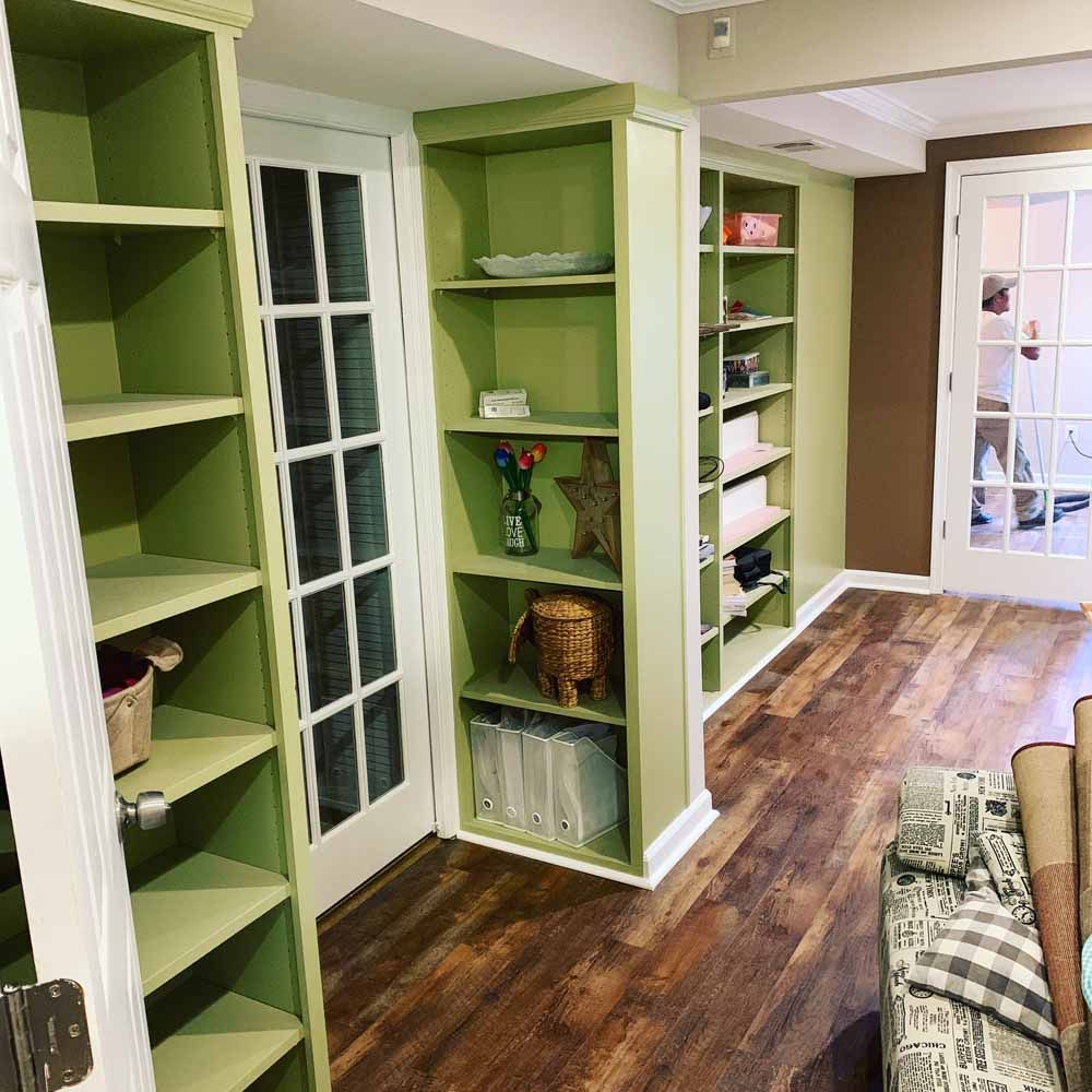 A living room with green shelves and french doors