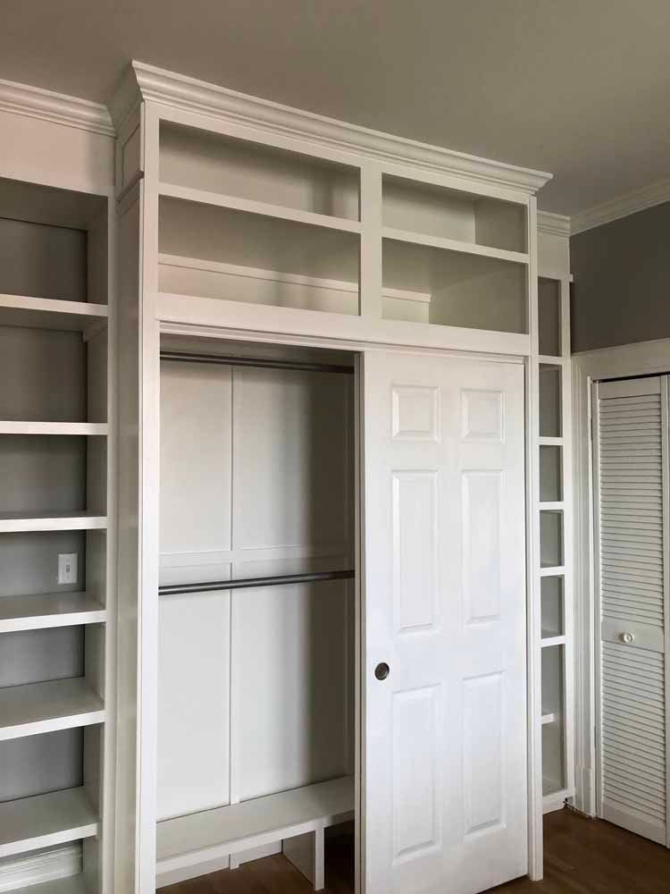 A closet with lots of shelves and a sliding door.