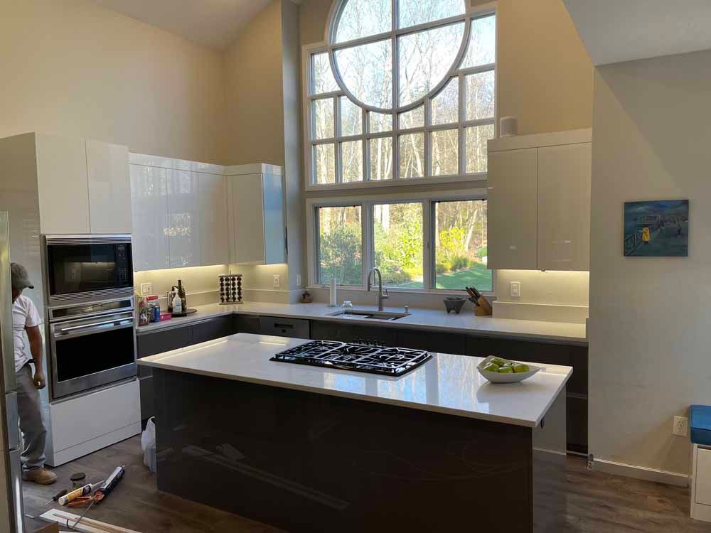 A kitchen with a large island and a large window.