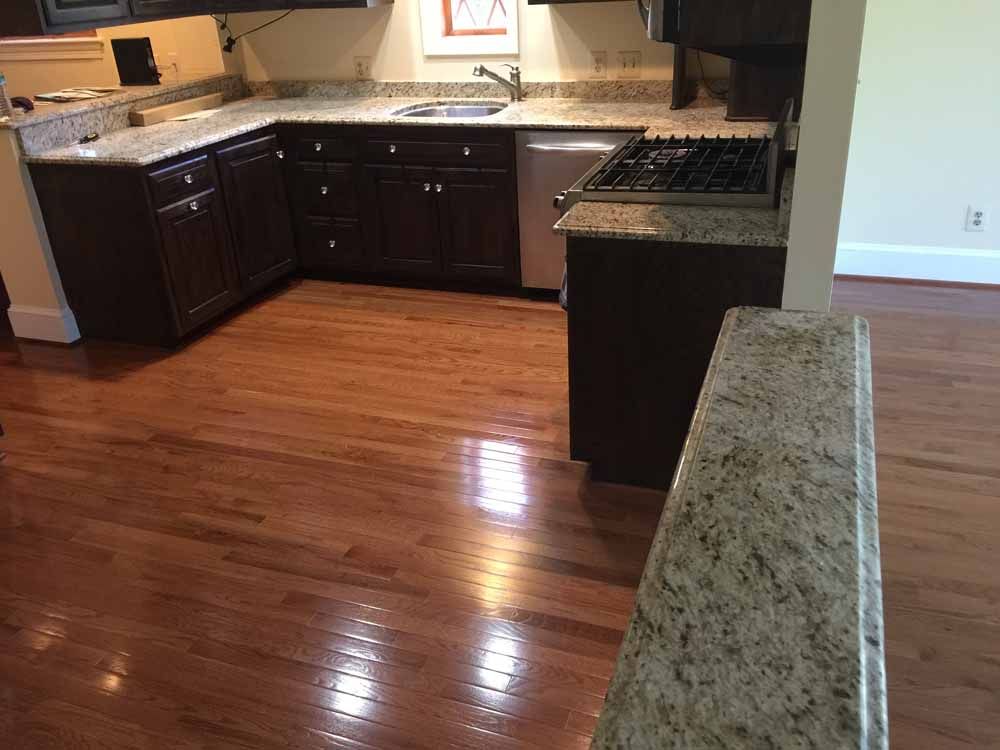 A kitchen with hardwood floors and granite counter tops