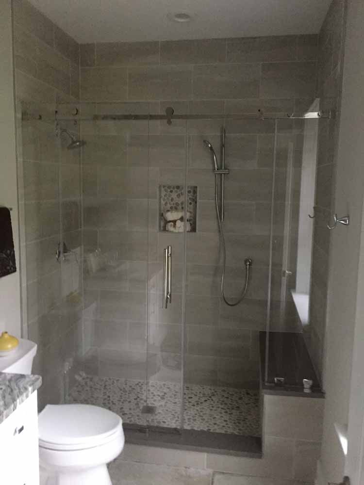 A bathroom with a toilet and a shower with a glass door.