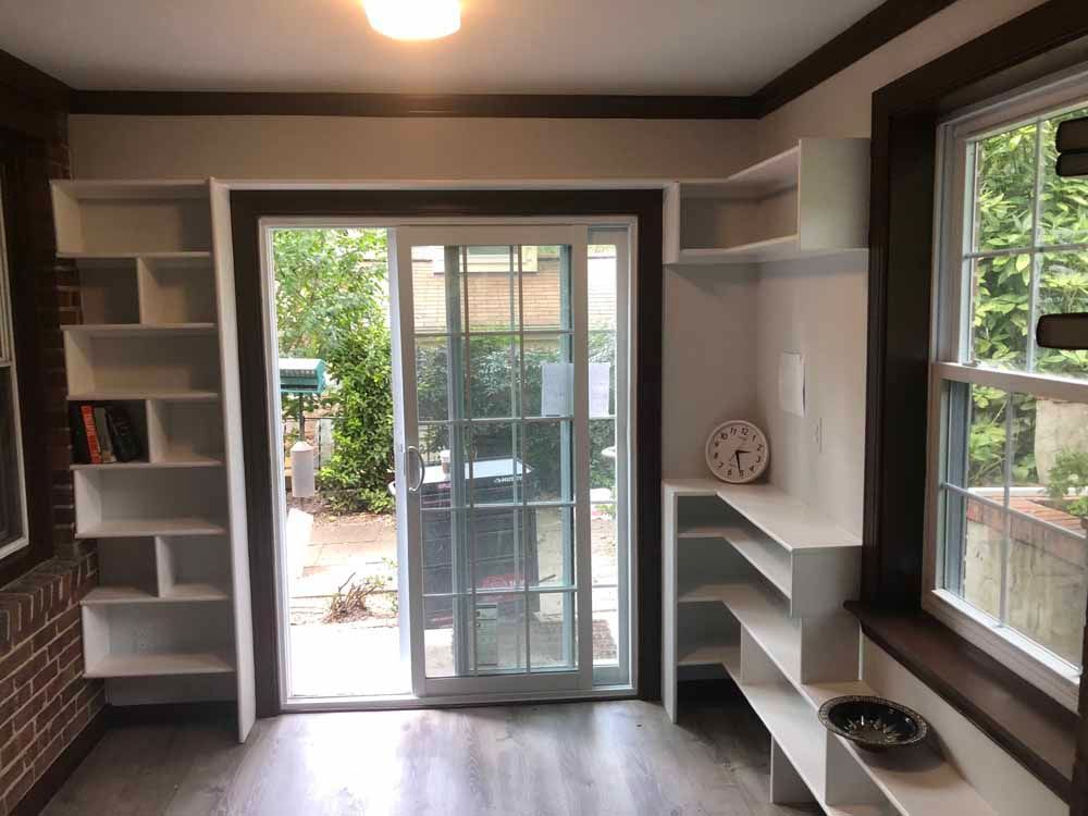 A room with a sliding glass door and shelves.
