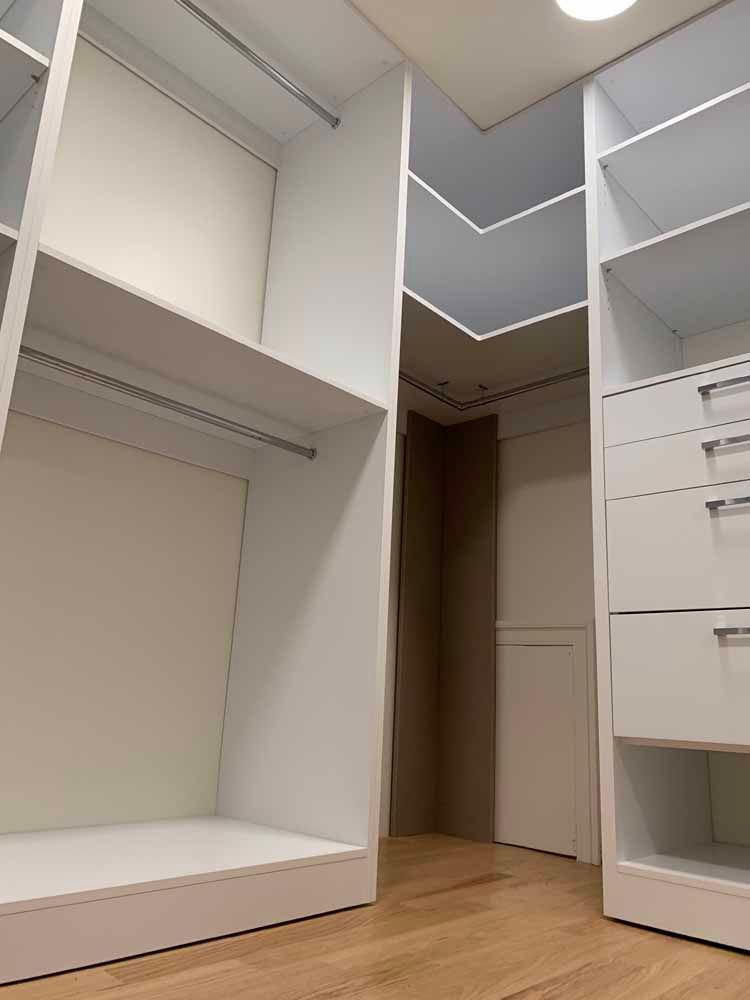 A walk in closet with lots of shelves and drawers.