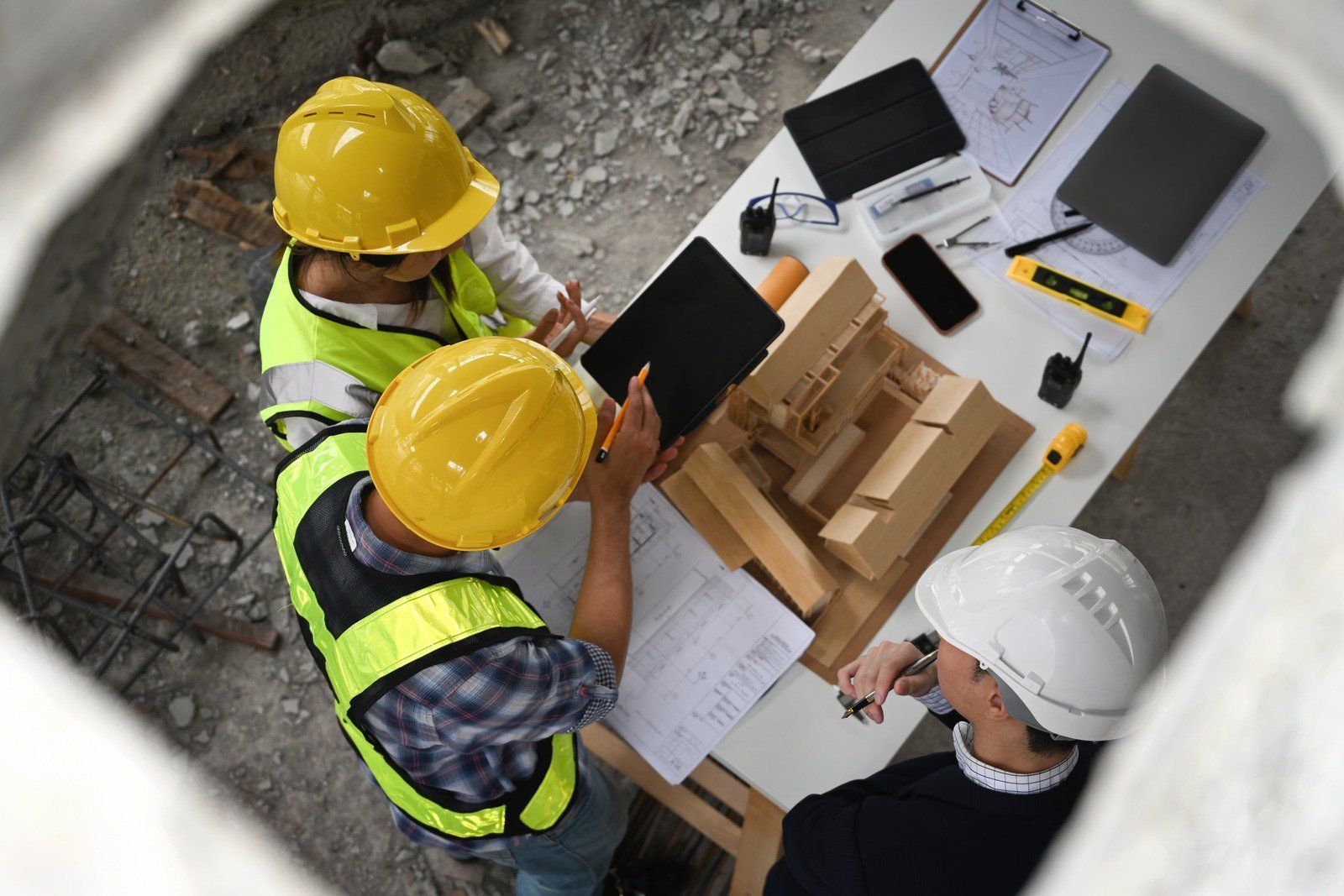 A man wearing a hard hat and goggles is standing in a room.