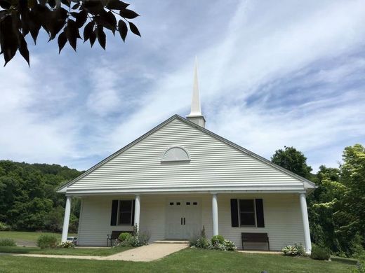 A small white church with a steeple on top of it