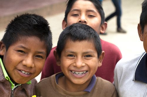 A group of young boys are posing for a picture and smiling for the camera.