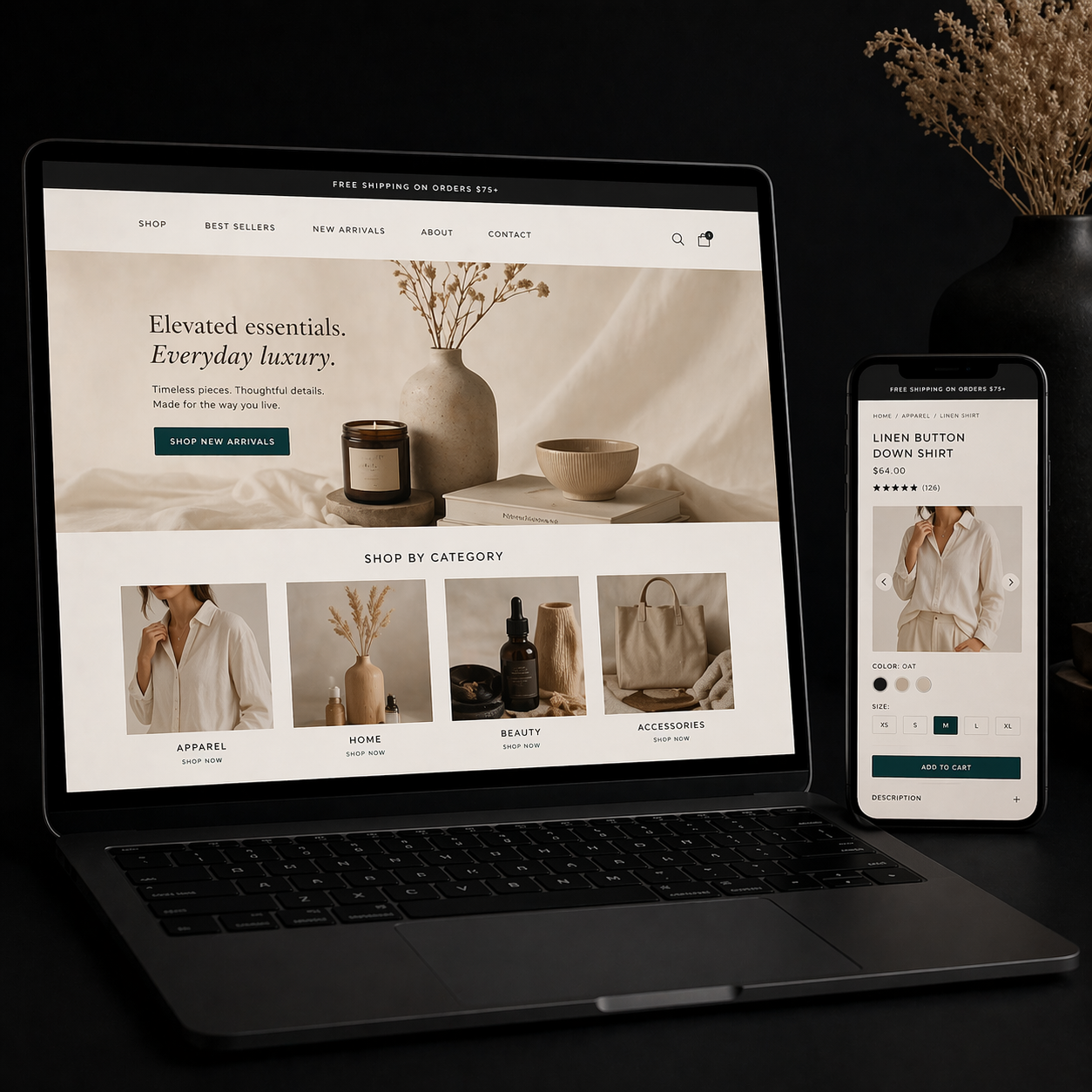 Laptop and phone displaying a minimalist beige fashion website on a dark desk with dried flowers