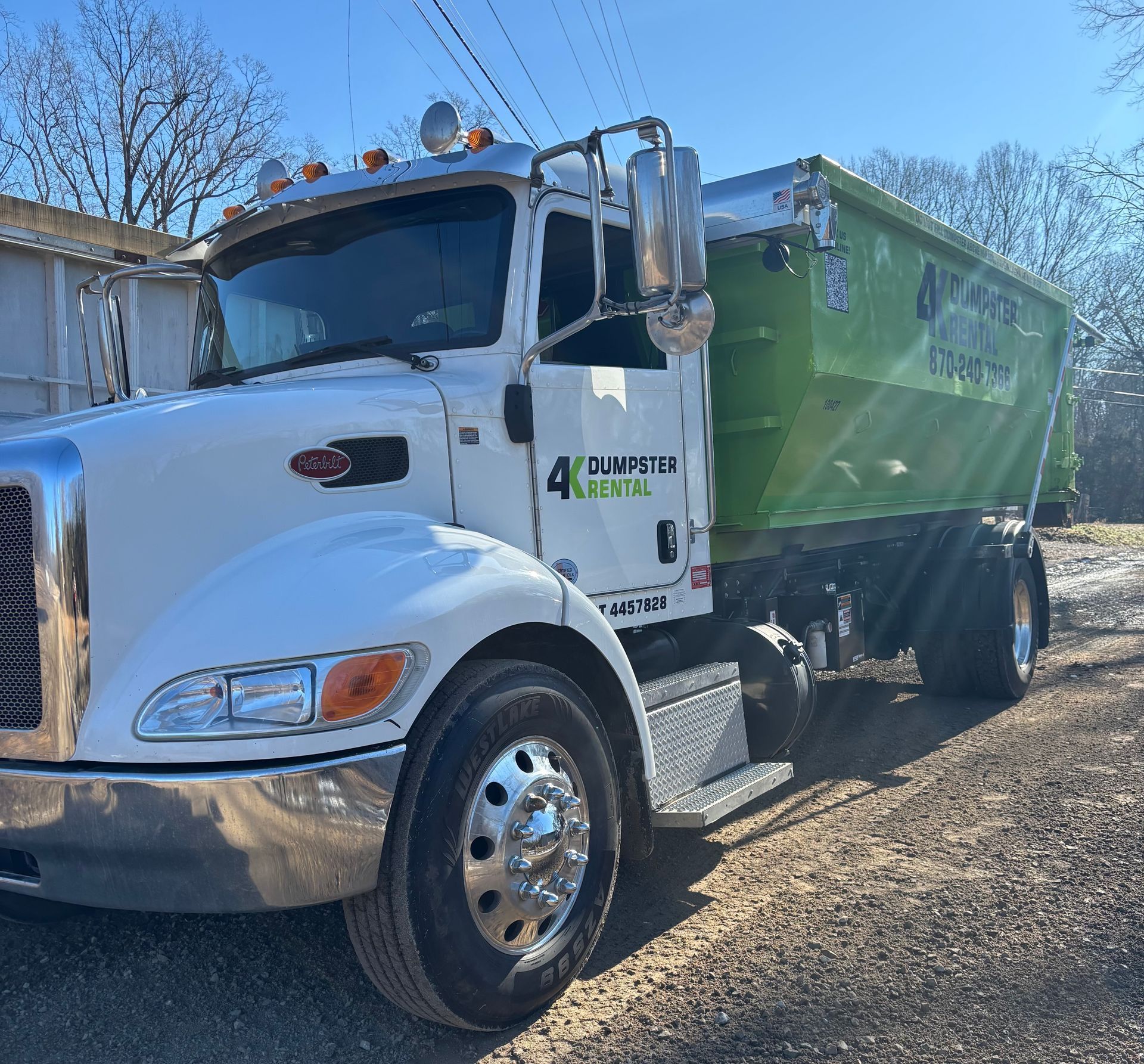 A dumpster is parked in the snow in front of a house.