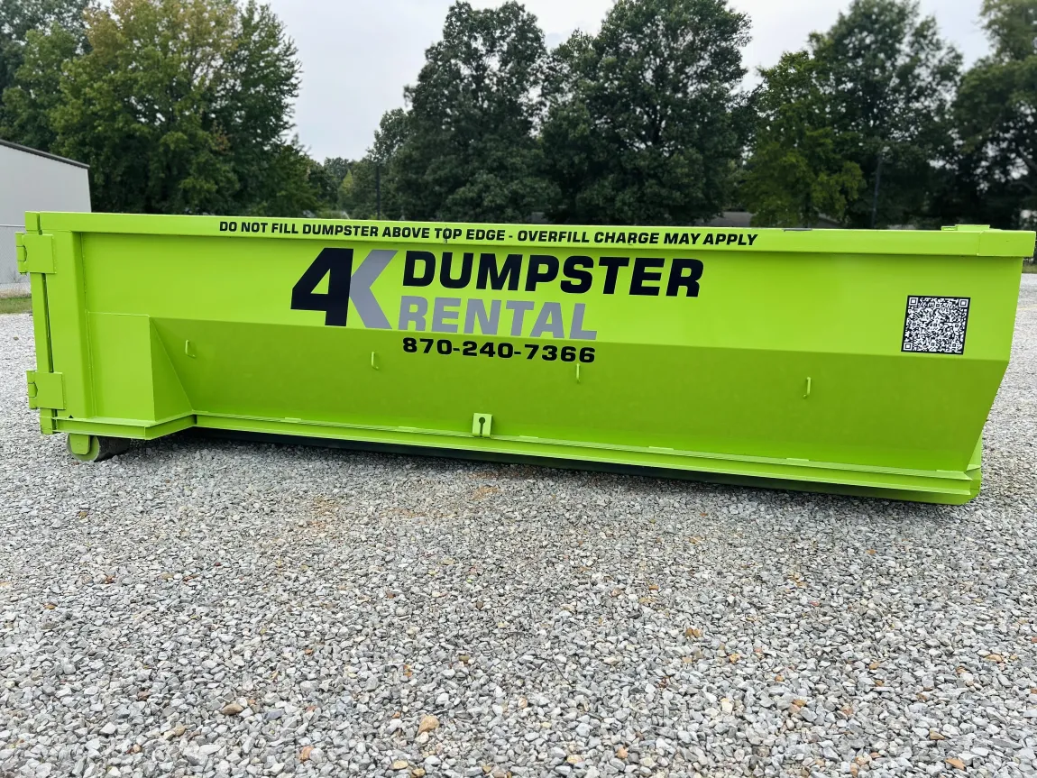 A group of people standing in front of a dumpster.