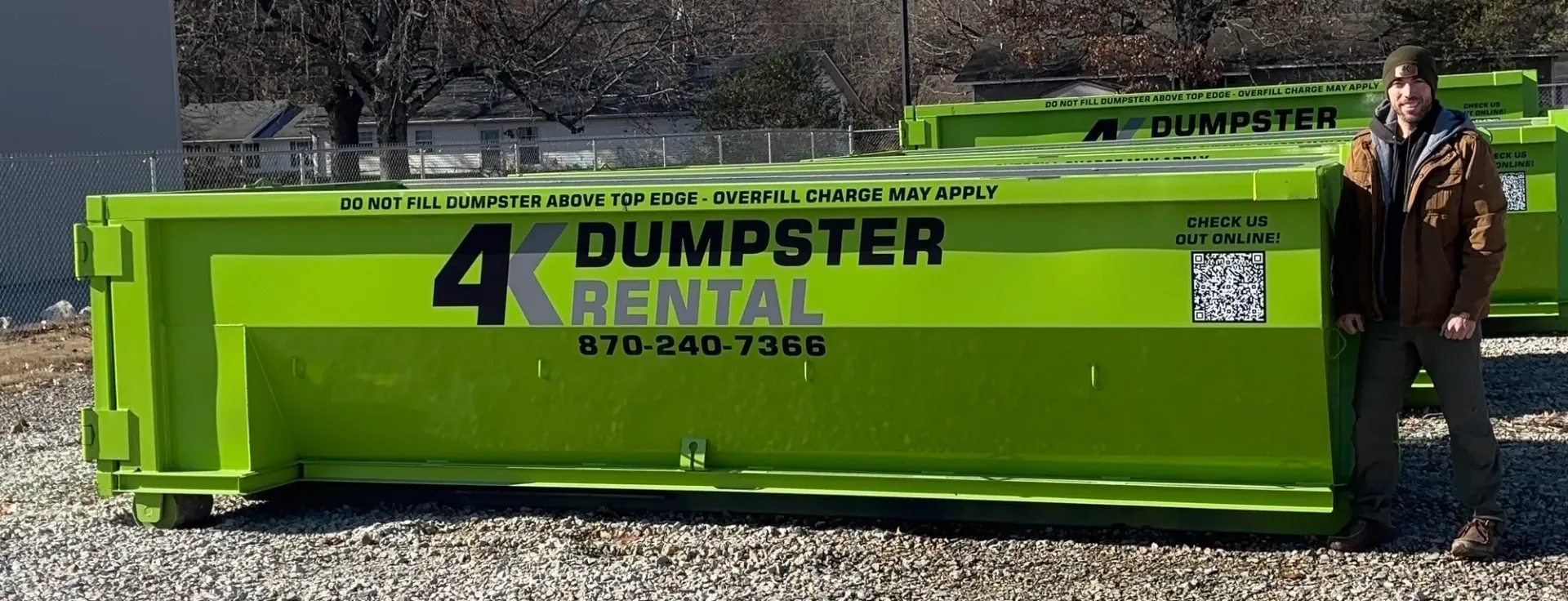 A group of people standing in front of a dumpster.