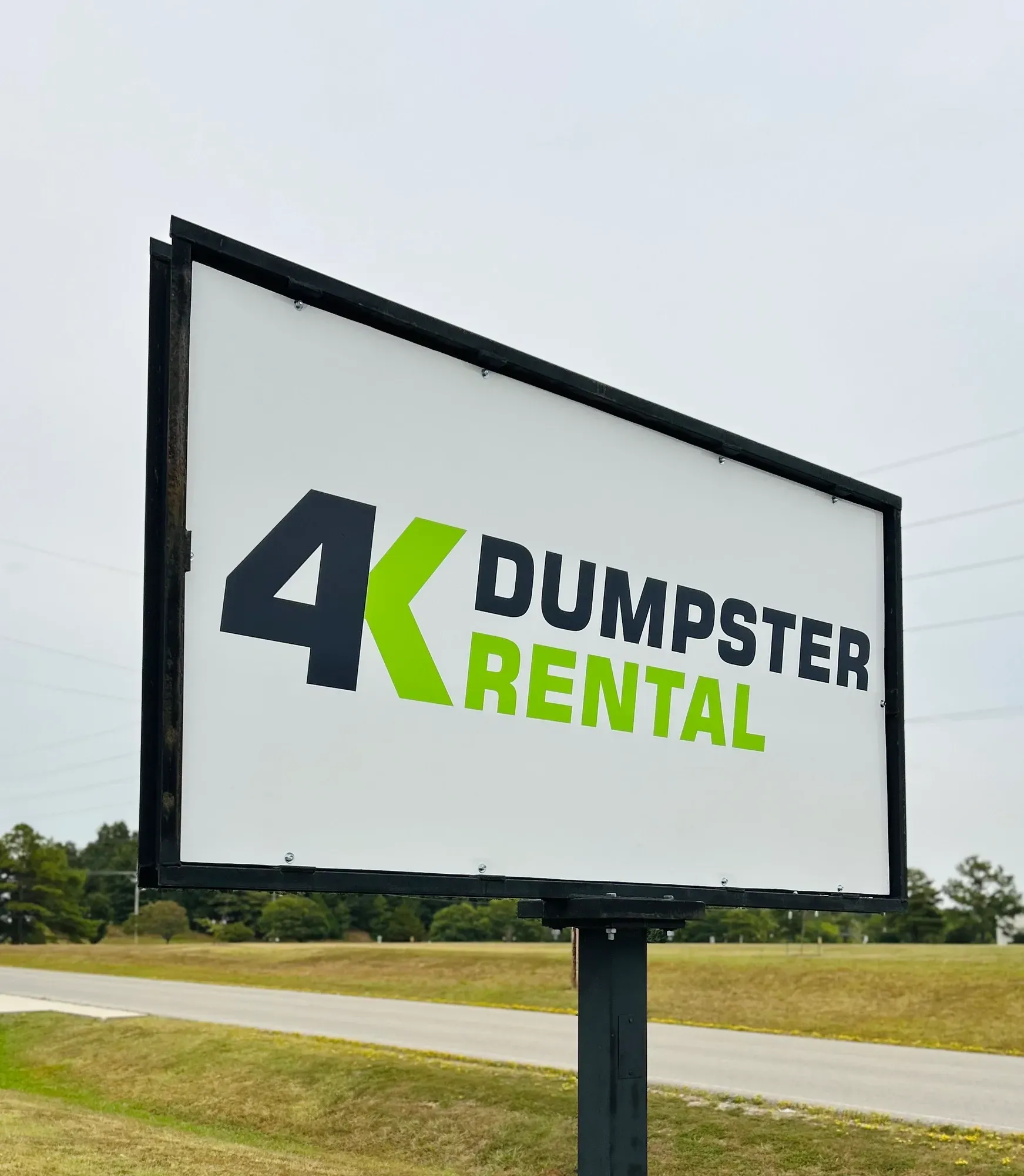 A dumpster is parked in the snow in front of a house.