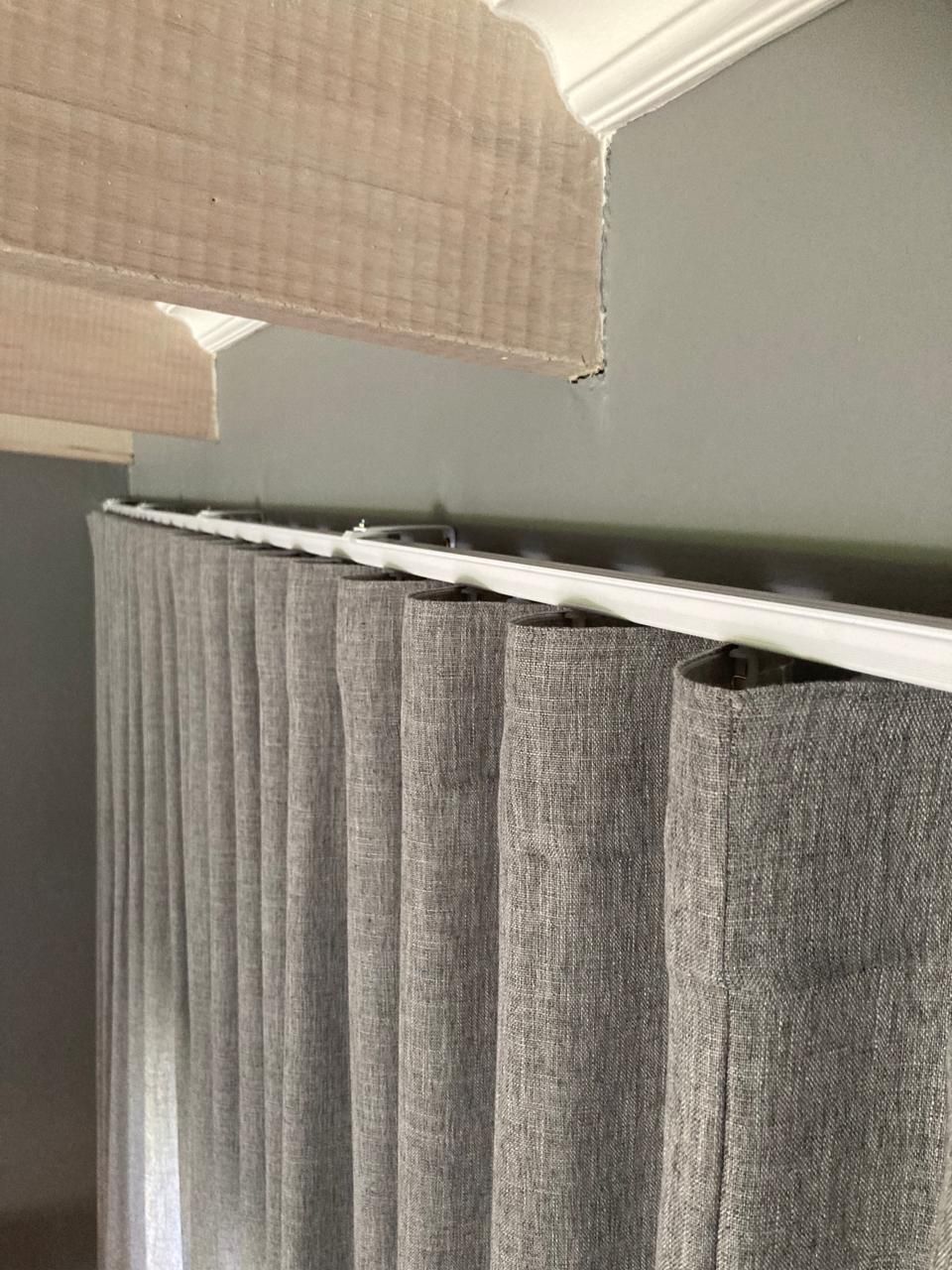 A close-up of a curtain rail with stylish curtains by Blind & Shutter City Pretoria East hanging from it.