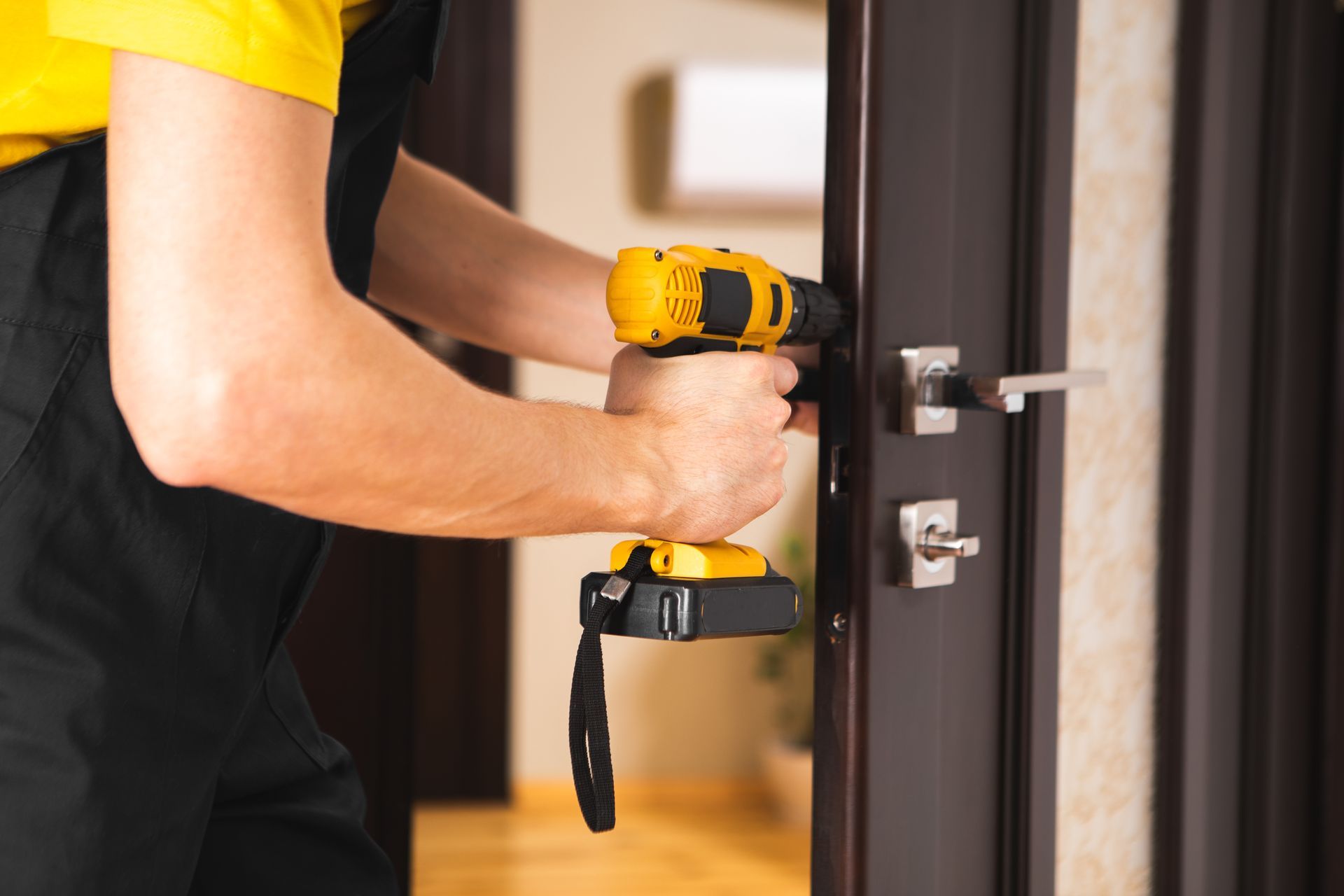 A man is fixing a door with a drill.