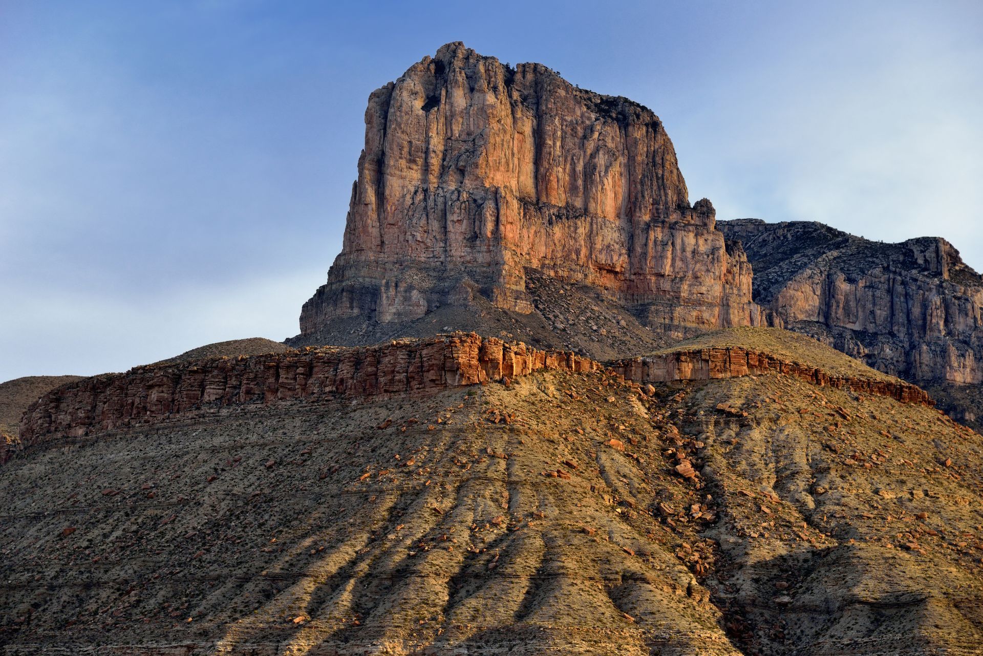 A theodolite is sitting on a tripod in the middle of a field.