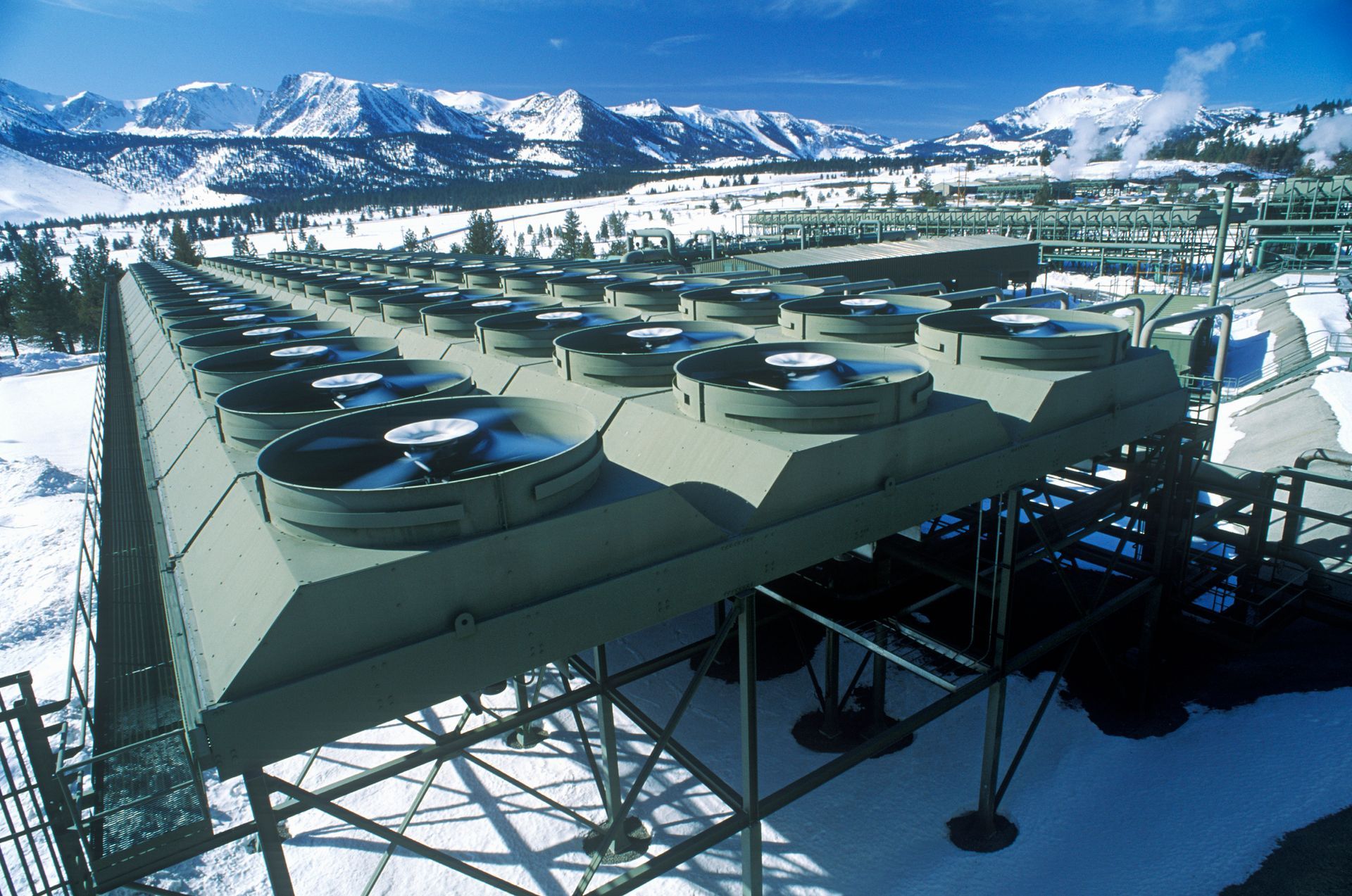 A field of solar panels and wind turbines.