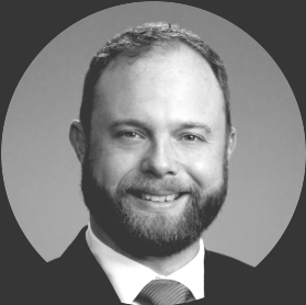 A man in a suit and tie is smiling for the camera.