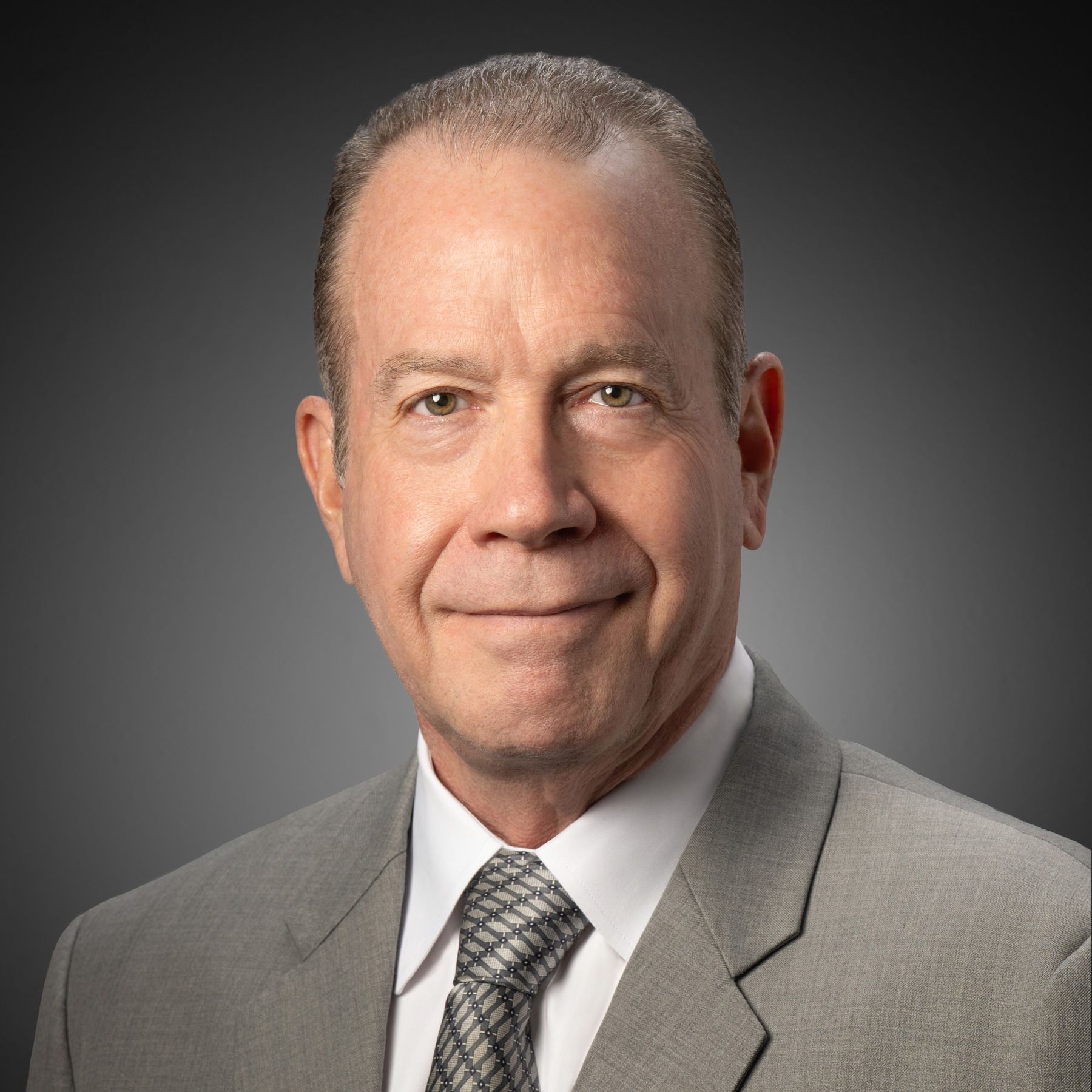 A man in a suit and tie is smiling for the camera.