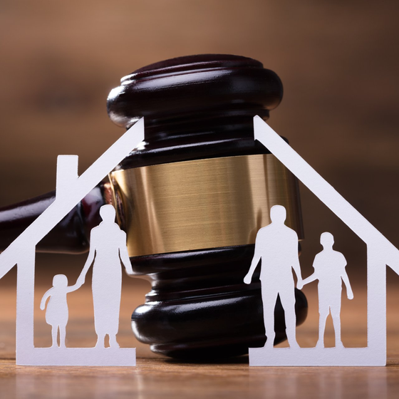 White Family Paper Cut Out In Front Of Judge Gavel On The Wooden Desk