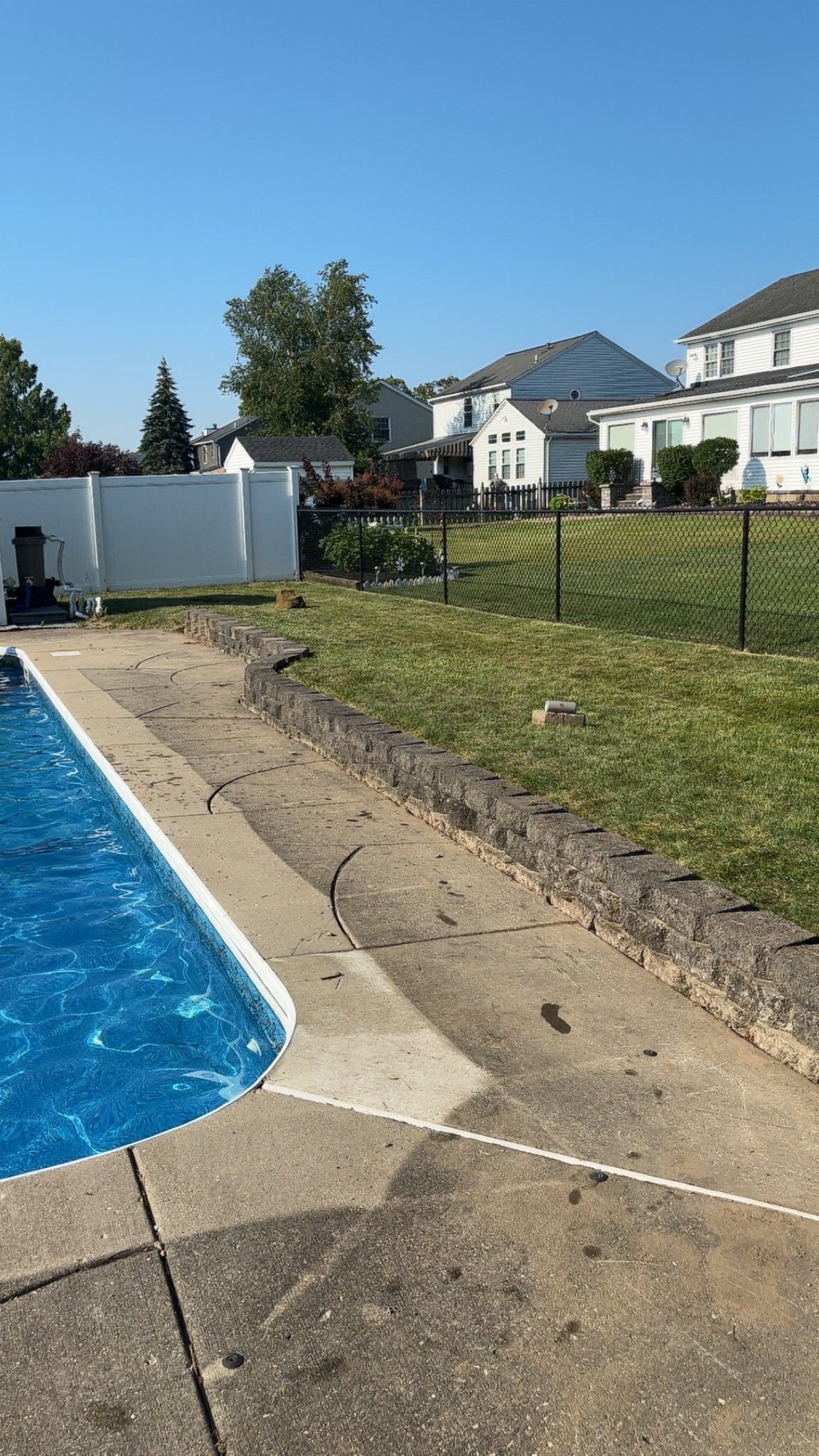 Wooden privacy fence in a grassy yard, with trees in the background.