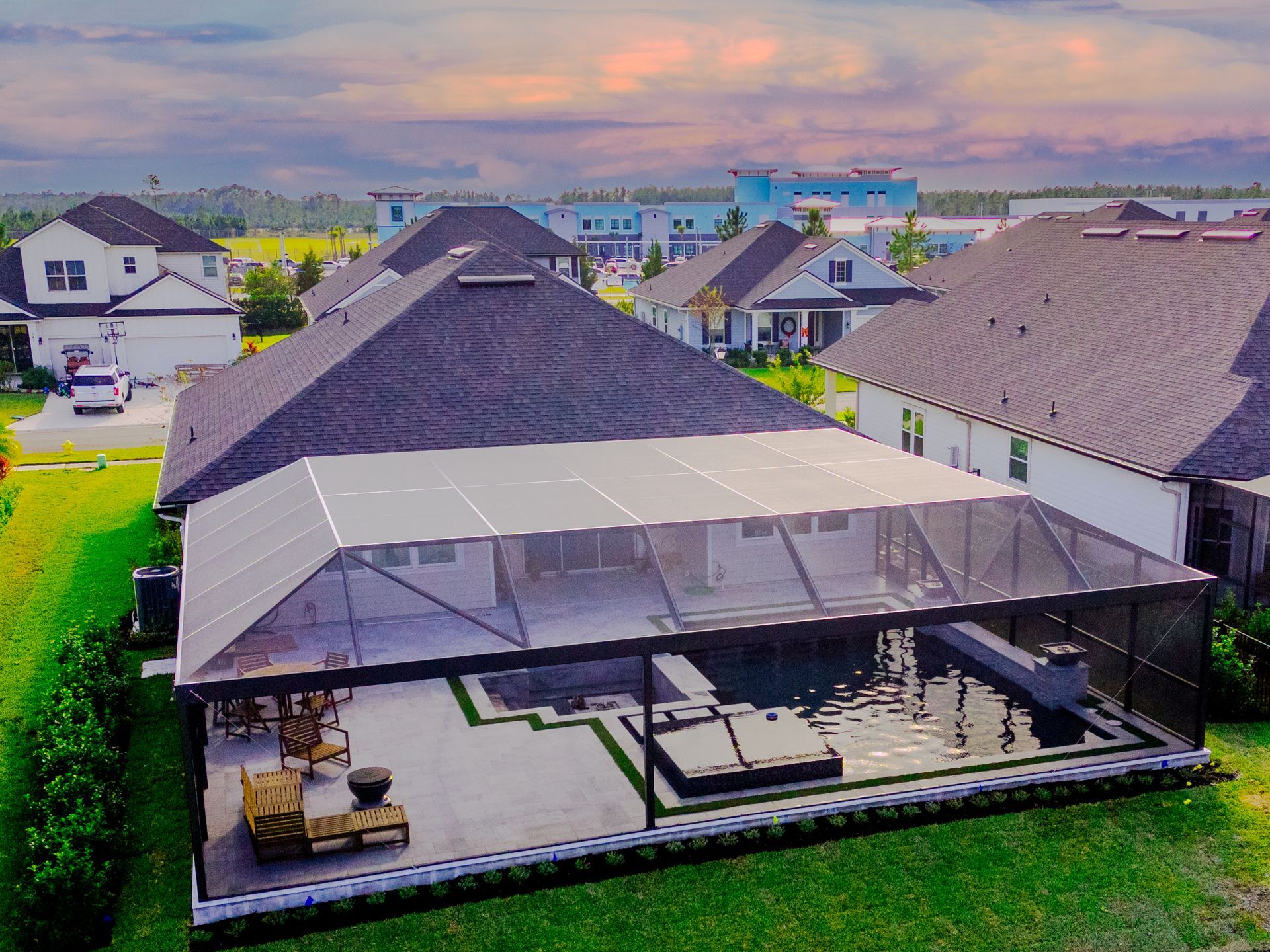 Infinity pool overlooking a body of water with docks, white umbrellas, and a cloudy sky.