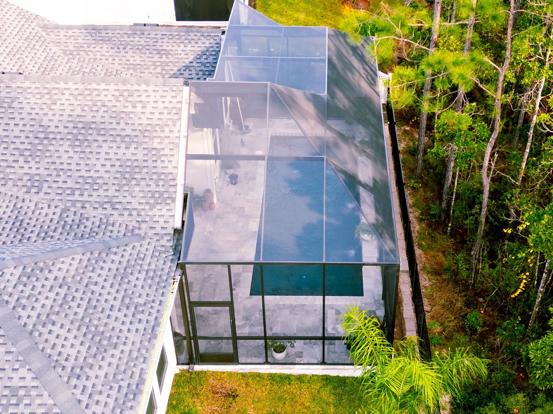 Infinity pool overlooking a body of water with docks, white umbrellas, and a cloudy sky.