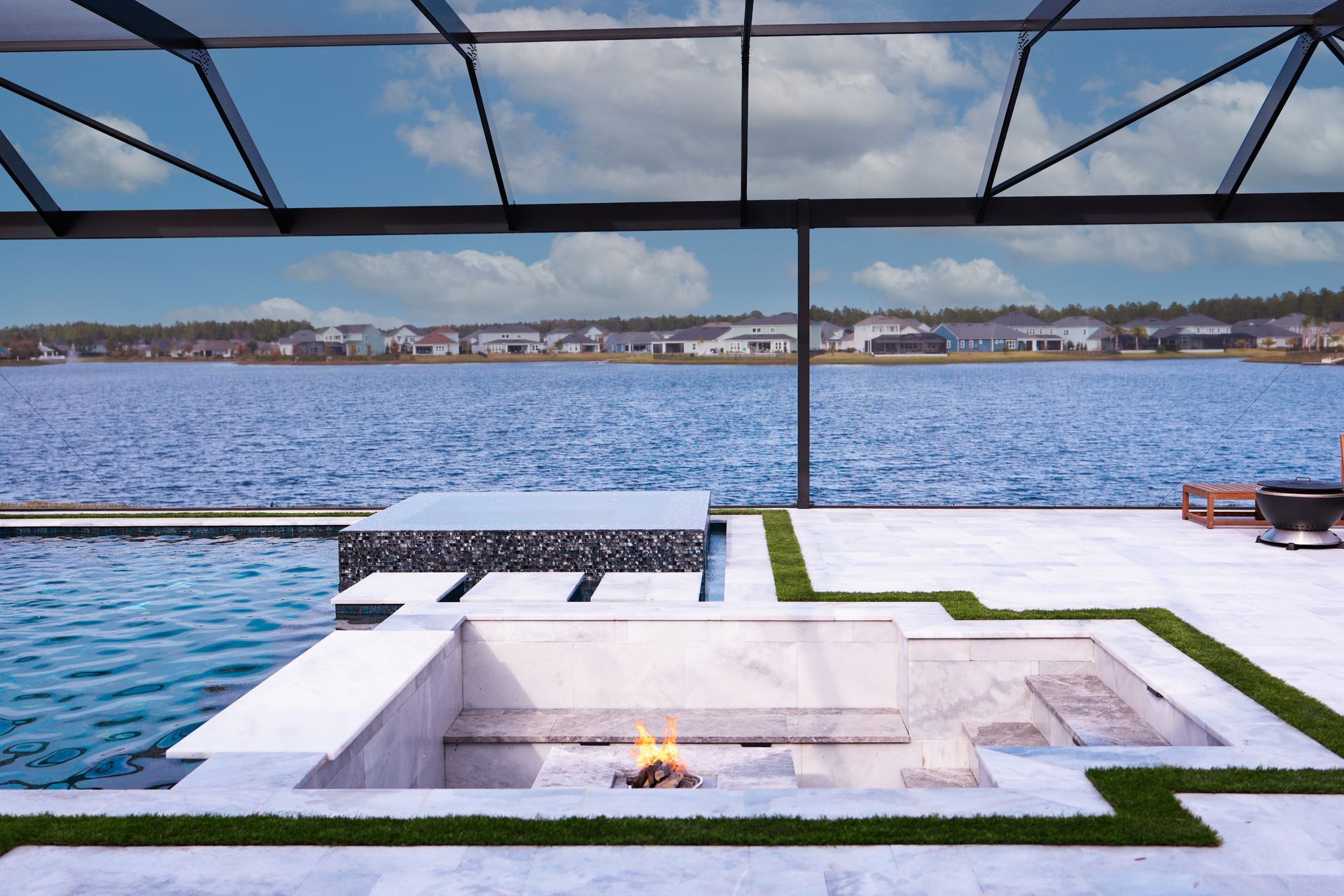 Modern house with pool, lawn, and sky; two-story, white with balcony.