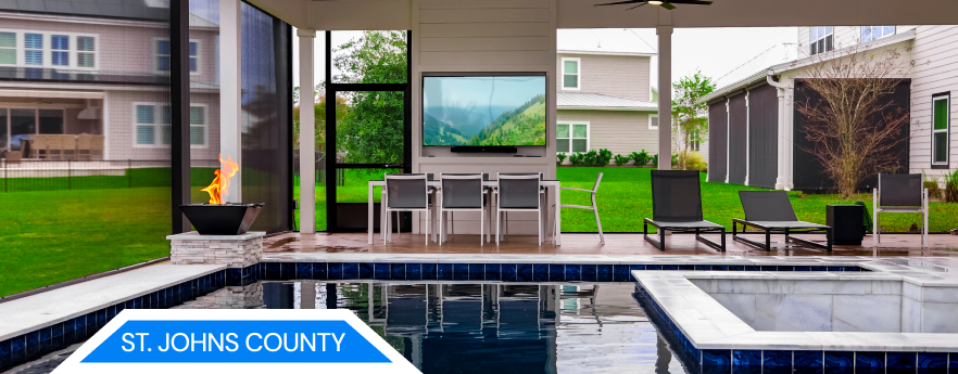 A luxury home in St. Johns County with a pool, umbrellas, and lush landscaping.