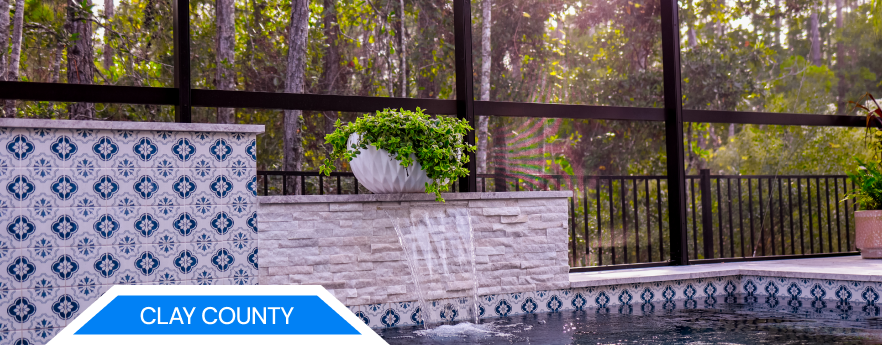 Clay County waterfront property with a pool and umbrellas overlooking a body of water.